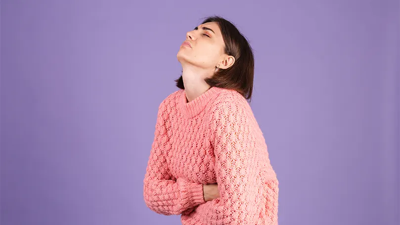 A woman holding her stomach in pain