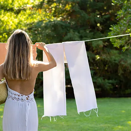 A woman hanging laundry to air dry outside