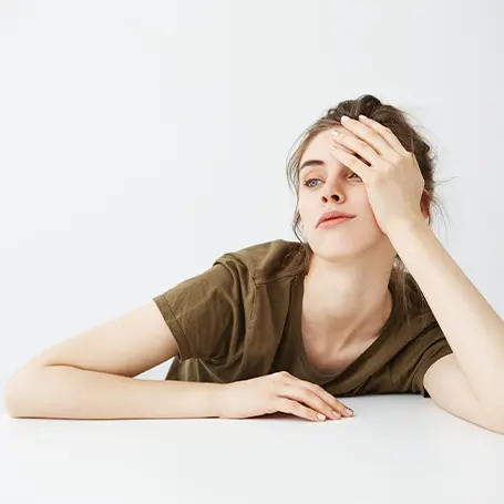 A young woman that is tired holding her head up