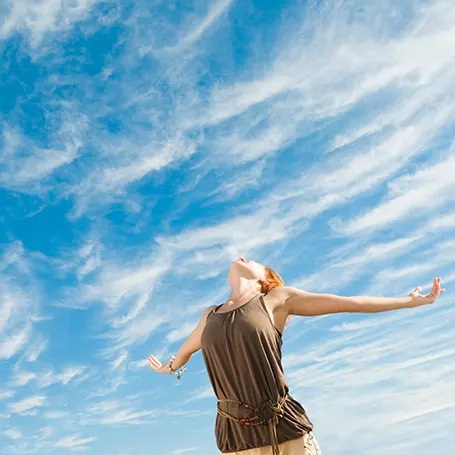 An image of a woman enjoying a clear sky.