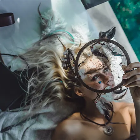 An image of a woman under a dreamcatcher