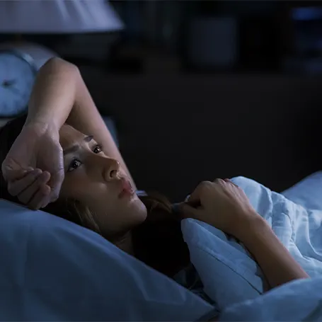 An image of a woman in bed suffering from sleep deprivaiton