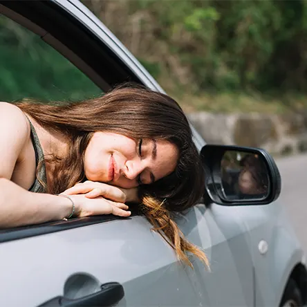 An image of a woman sleeping in her car.
