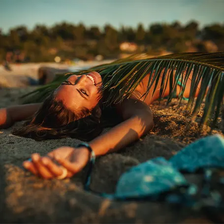 A young woman sleeping on the beach in the evening