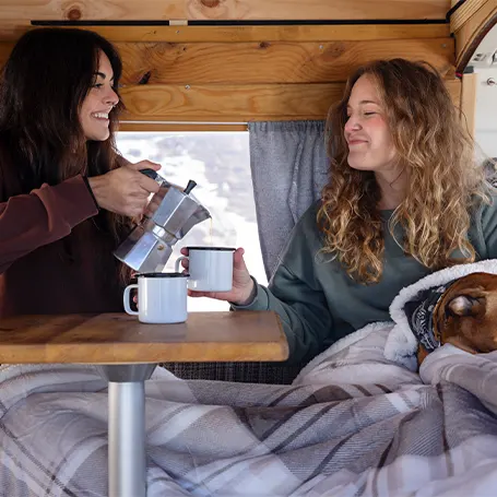 An image of two people sleeping in a van