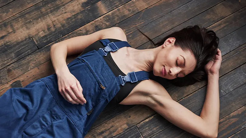 a woman sleeping on a flat wooden deck