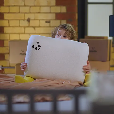 a child holding a Kids Panda Memory Foam Pillow