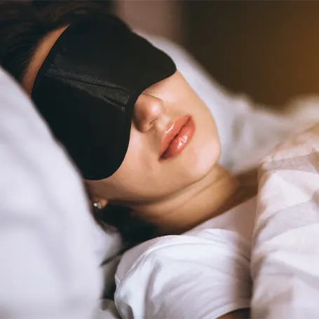 An image of a woman sleeping with a sleep mask