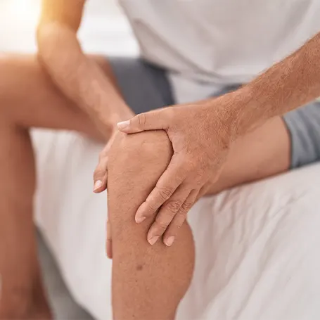 An image of a man with throbbing leg pain