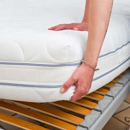 a man pressing a mattress and checking a firmness