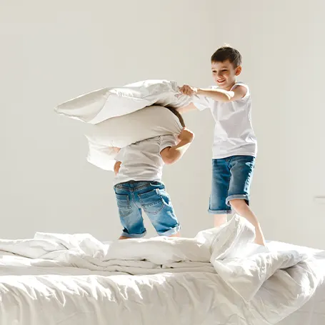 An image of two children having a pillow fight
