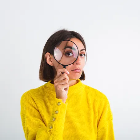 An image of a woman looking through a magnifying glass