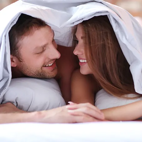 a couple in bed under a low tog duvet