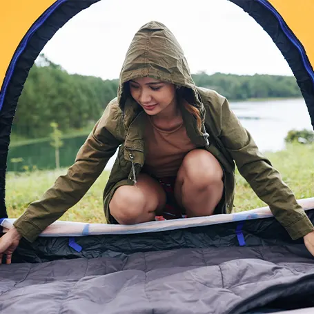 An image of a woman setting up a tent