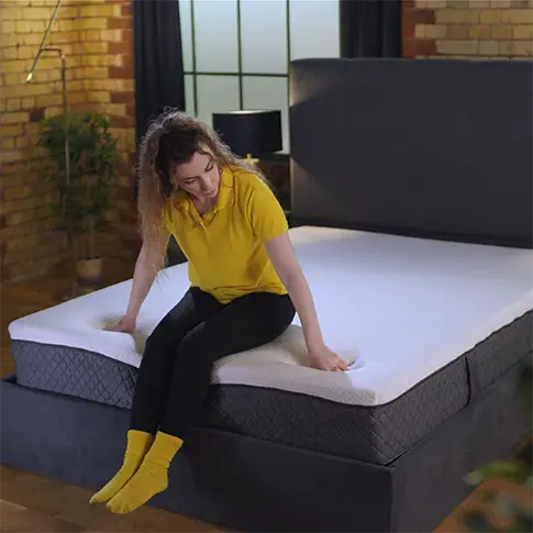 our reviewer Connie testing the edge support of Emma Nextgen Premium mattress
