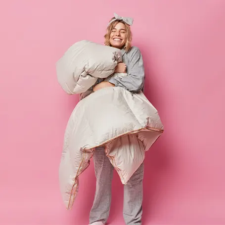 An image of a woman holding an anti allergy duvet