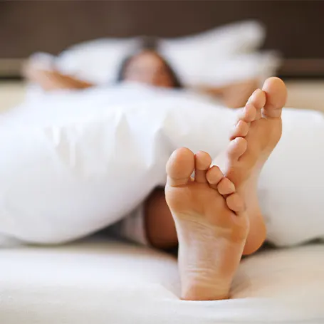 An image of a woman sleeping in bed with her anti allergy bedding