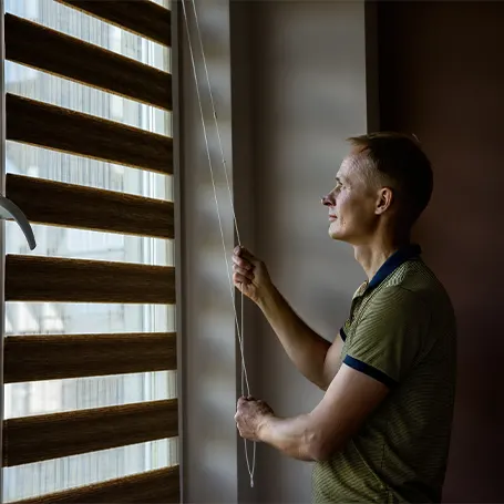 An image of a person adjusting their blackout blinds