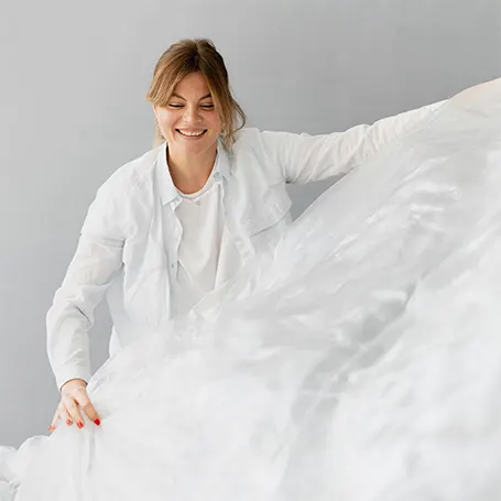 An image of a woman putting on a mattress cover.