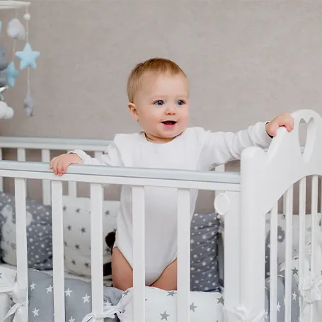 An image of a baby standing in the crib