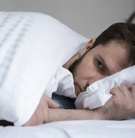 An image of a man trying to sleep.