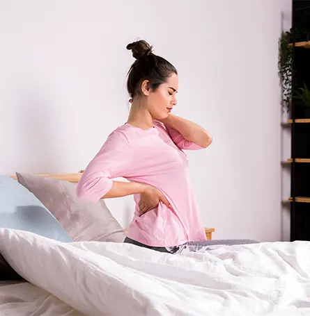An image of a woman in bed with back pain