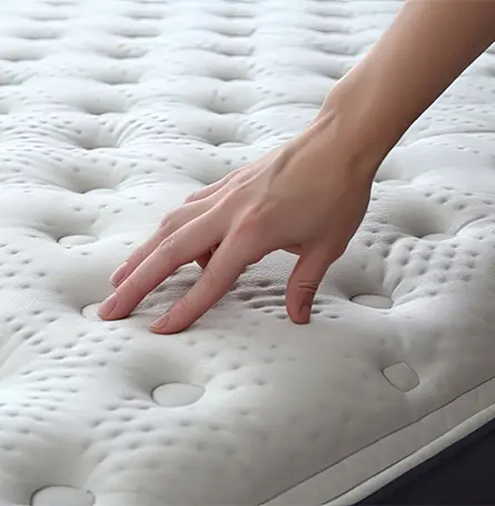 An image of a person pressing down on a memory foam mattress