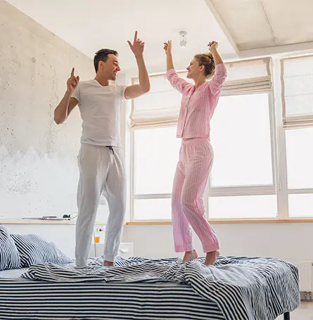 An image of a couple of early birds jumping on a bed