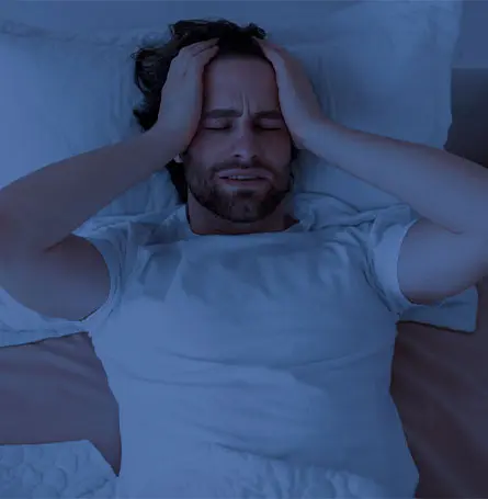 An image of a man in bed unable to fall asleep