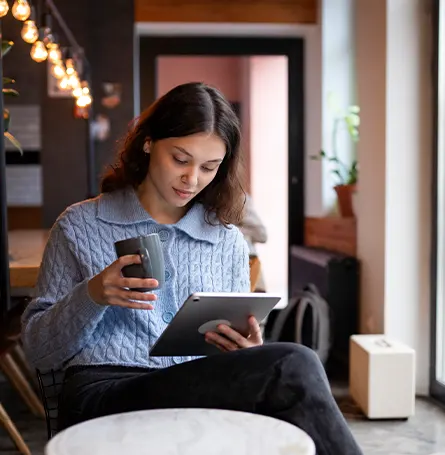 An image of a woman reading from her tablet and staying informed