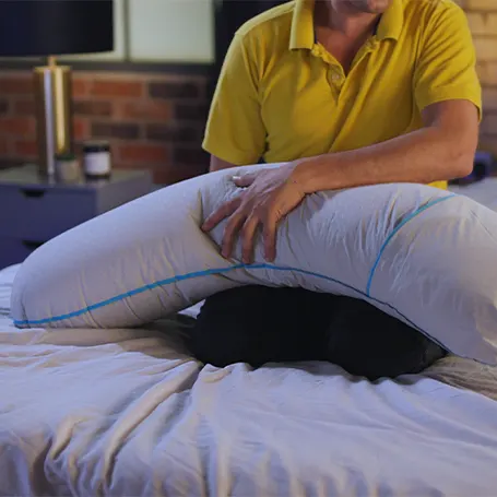 Presenter squishing the Simba Cooling Body Pillow.